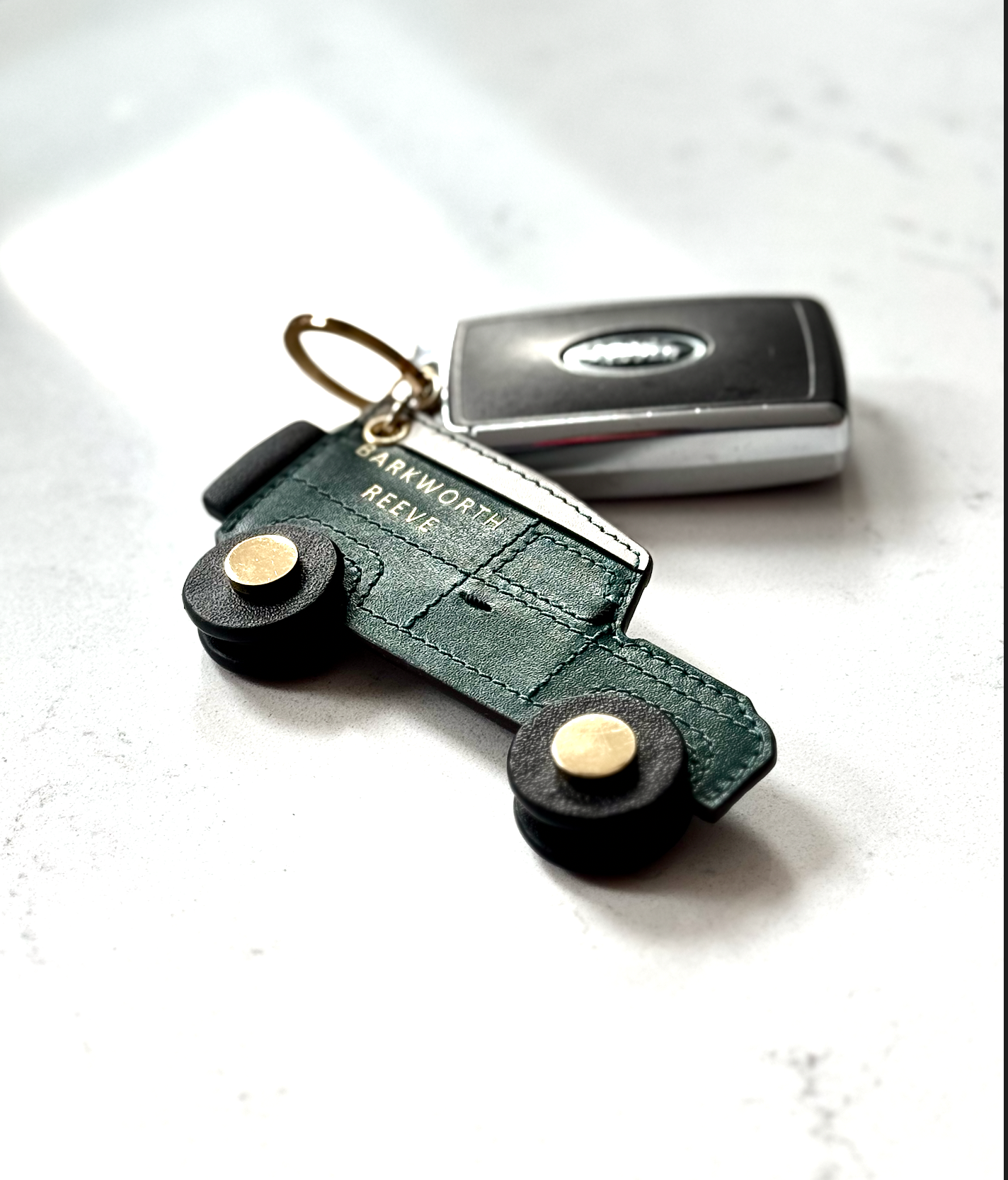 Green and cream 4x4 off road truck keyring on white background with car keys