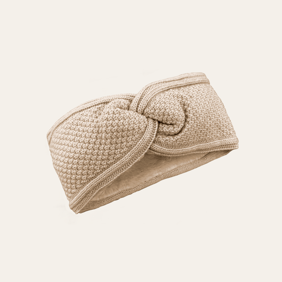 A beige knitted headband made of cashmere mix yarn, fully lined with teddy fleece, displayed against a white background.