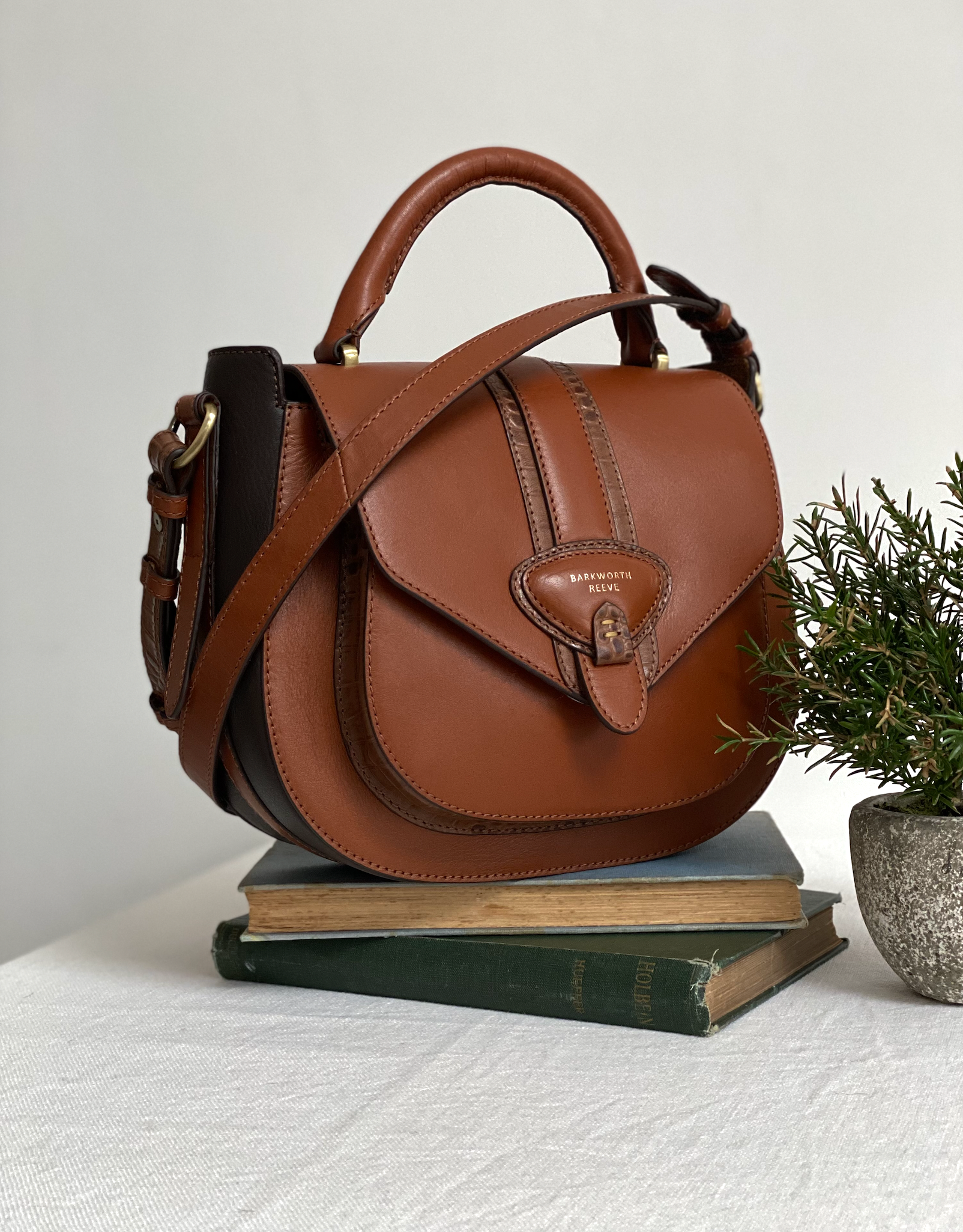 Belton two tone Tan leather saddle bag by barkworth Reeve on a pile of books