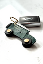 Green and cream 4x4 off road truck keyring on white background with car keys