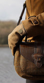 TWEED AND CROC LEATHER SADDLE BAG, ZOOMED IN ON A WOMAN SHOULDER INFRONT OF A LAKE