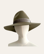 A wide brimmed fedora hat in soft olive green, displayed on a mannequin head.