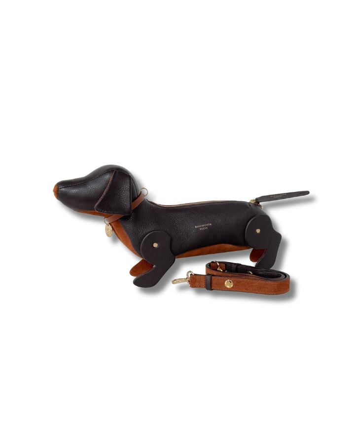 Chocolate Leather sausage dog handbag with leather strap laid next to bag