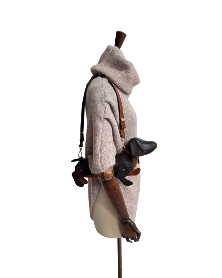 oat marl poncho on a mannequin with a Chocolate Leather sausage dog handbag over her shoulder