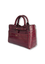 A structured handbag in embossed crocodile-look leather in a deep burgundy red, featuring dual top handles, a front flap pocket, and gold-tone hardware. The brand name 'PETERSEN PARIS' is visible in gold lettering on the front.