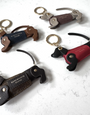 multi coloured leather sausage dog keyrings laid out on marble table top 