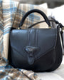 Black handbag with 'Barkworth Reeve' logo on a plaid fabric background