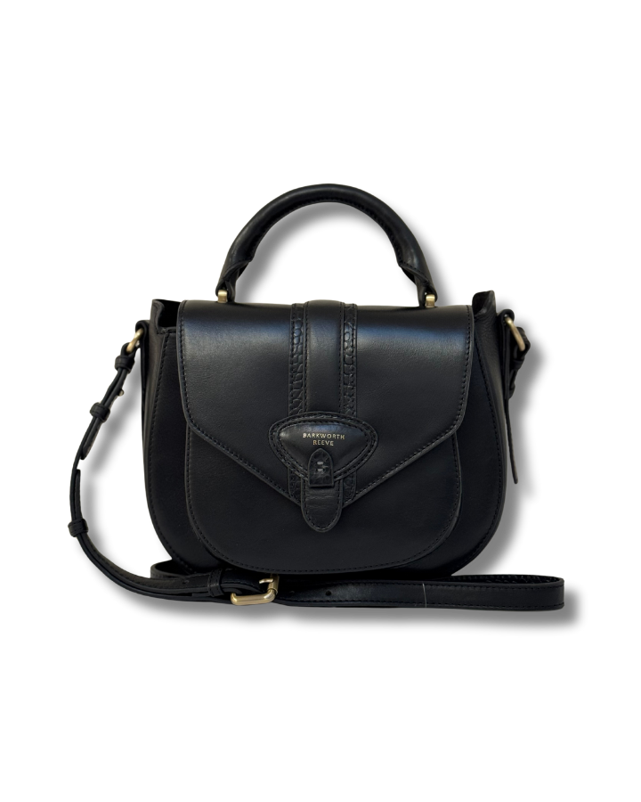 Black leather handbag with a strap on a white background