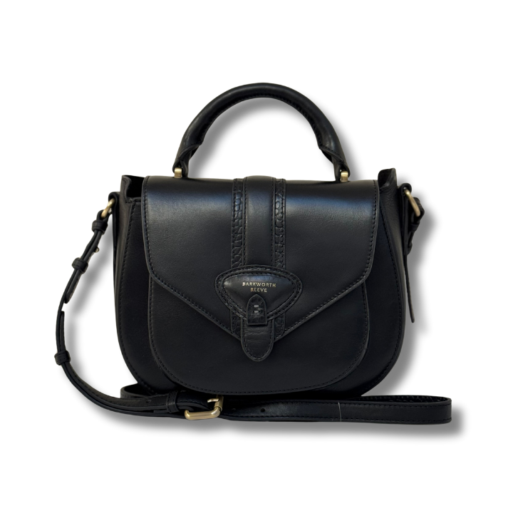 Black leather handbag with a strap on a white background