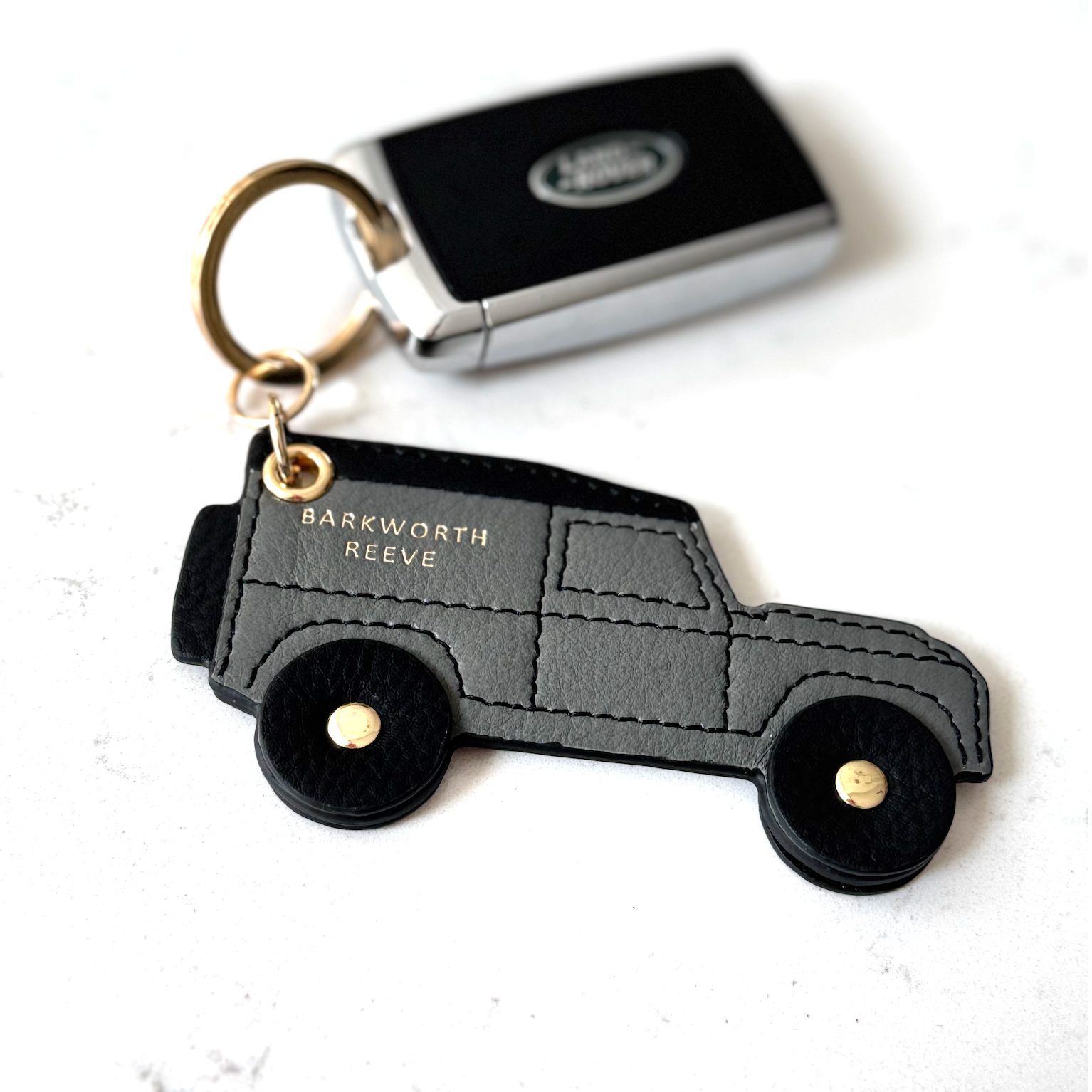 Keychain shaped like a car with 'Barkworth Reeve' branding on a white background