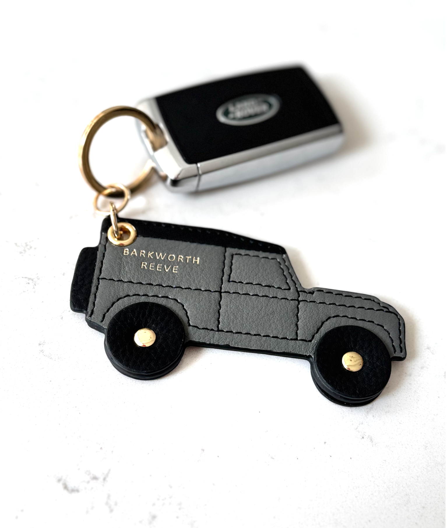 Keychain shaped like a car with 'Barkworth Reeve' branding on a white background