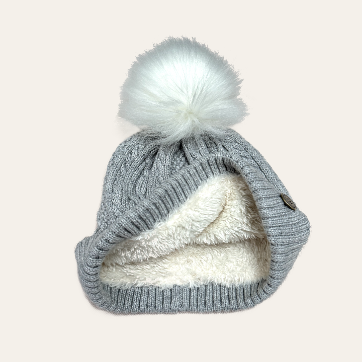light grey marl bobble hat folded back with the faux fur liining and a white fur pom