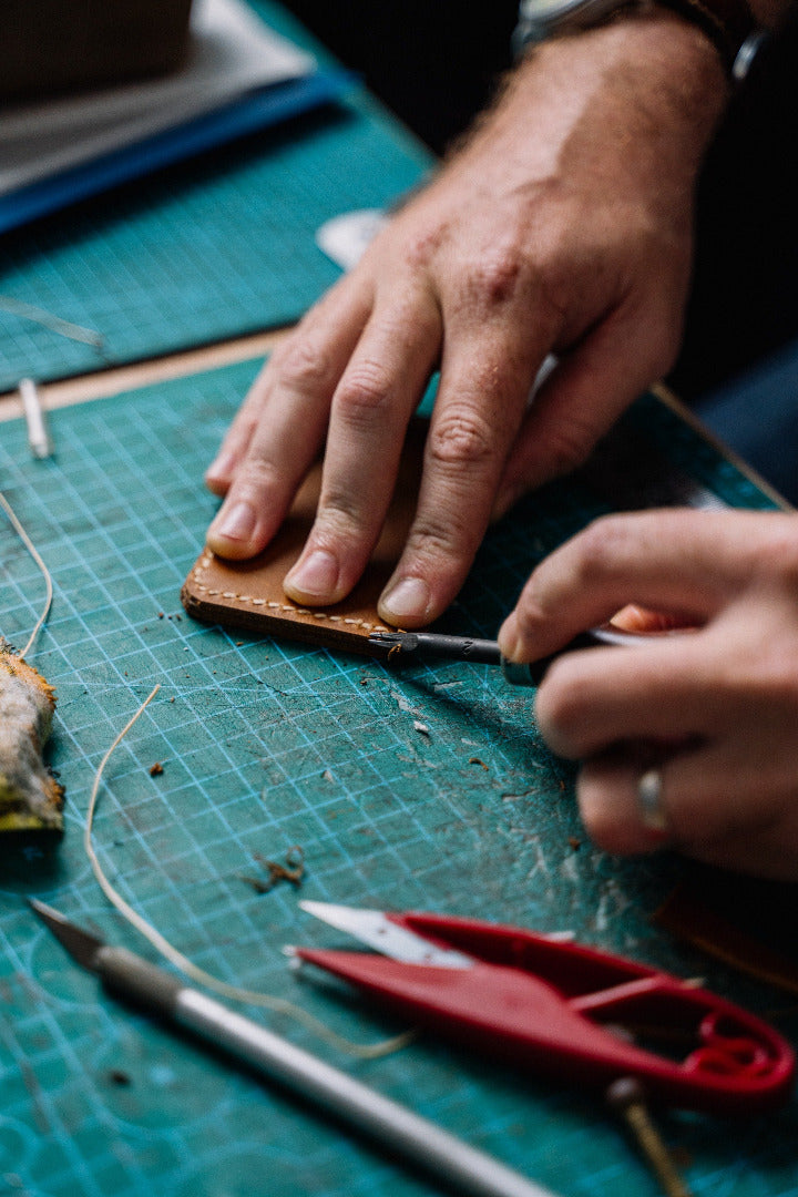 Person working on a craft project with tools on a green cutting mat