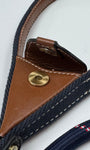 Close-up of a lead leather and fabric strap with a brass popper and leather pocket