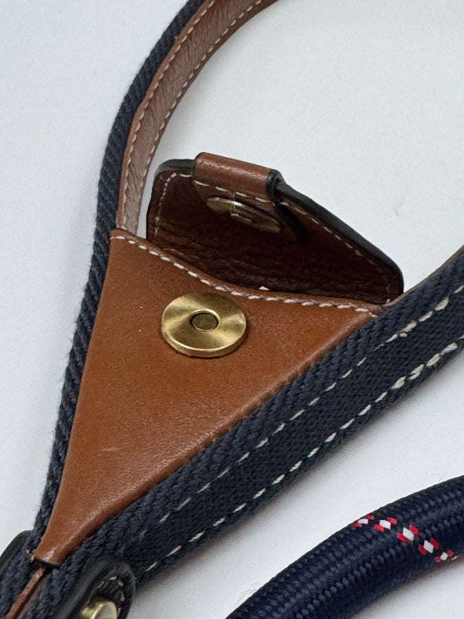 Close-up of a lead leather and fabric strap with a brass popper and leather pocket