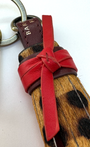 zoomed in detail on leopard tassel keyring with red leather tie