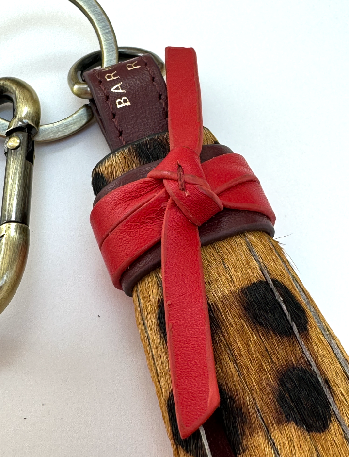 zoomed in detail on leopard tassel keyring with red leather tie