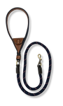 Navy dog leash with brown leather handle. Intergrated tan leather pocket brass hardware on a white background