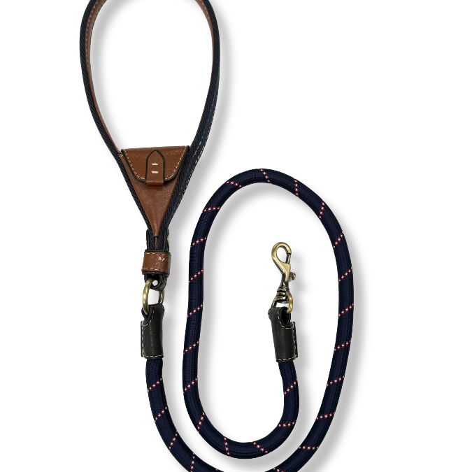 Navy dog leash with brown leather handle. Intergrated tan leather pocket brass hardware on a white background