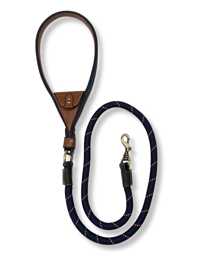 Navy dog leash with brown leather handle. Intergrated tan leather pocket brass hardware on a white background