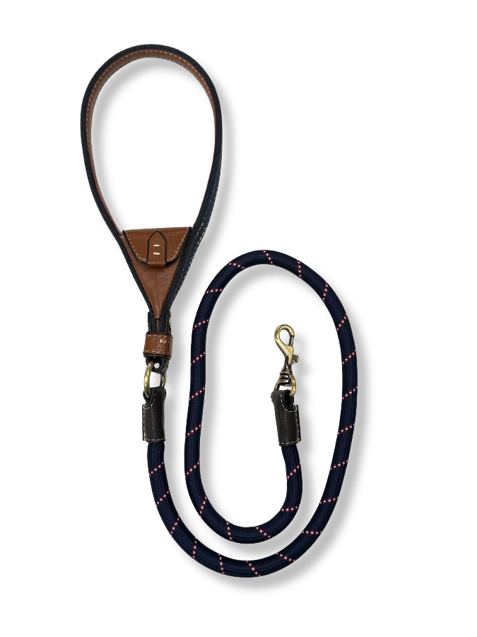 Navy dog leash with brown leather handle. Intergrated tan leather pocket brass hardware on a white background