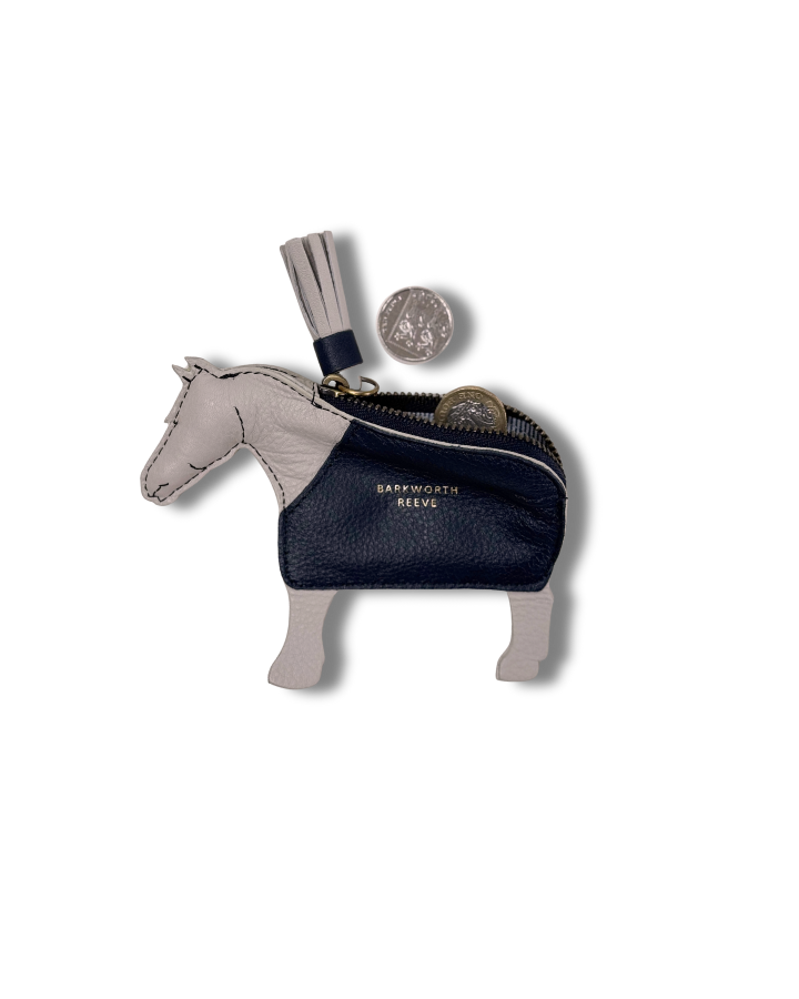 light grey leather coin purse in the shape of a pony with a navy coat.open with change coming out and tassel tail zipper