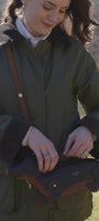 woman in the countryside on suunny day with sausage dog handbag 