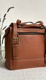 brown leather rucksack from the back with some lavender 