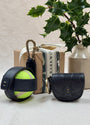 navy leather croc treat pouch, navy tennis ball holder with plant and present in background