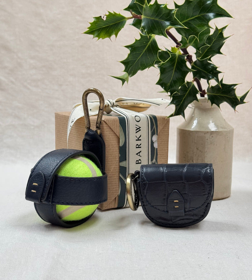 navy leather croc treat pouch, navy tennis ball holder with plant and present in background