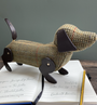 tweed sausage dog pencil case stood on top of a notebook