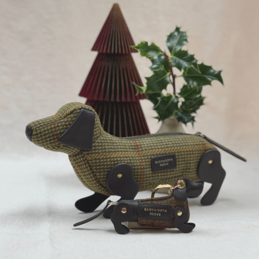 Sausage dog pencil case and keyring in front of paper christmas tree and foliage